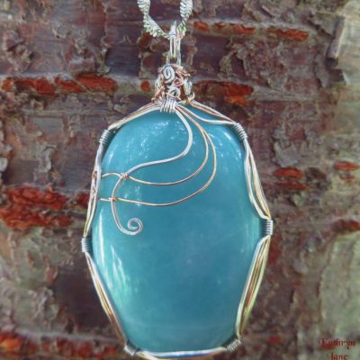 Large amazonite with symmetrical supports of sterling silver and copper. Earlier design.