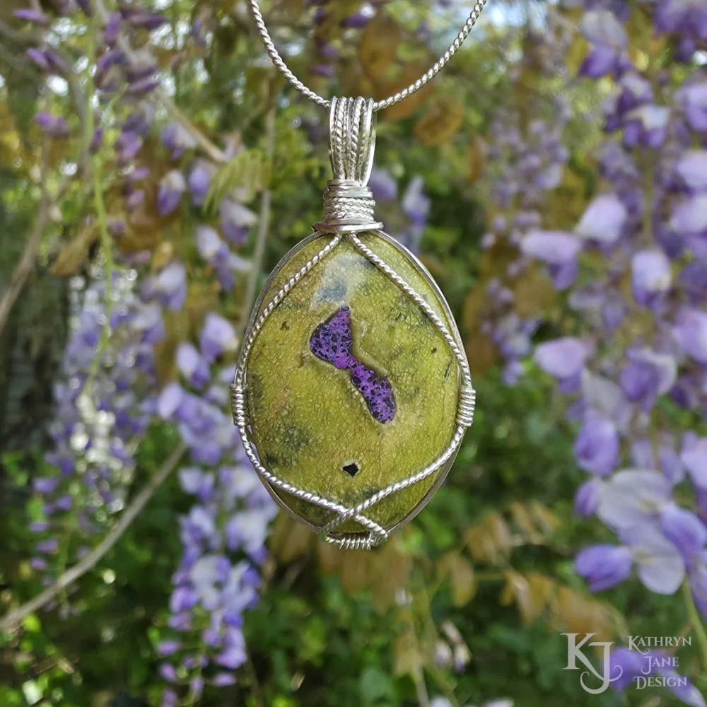 The single twisted silver strand provides a freely flowing, open frontal support for this oval-shaped Atlantisite pendant (stichtite in serpentine).