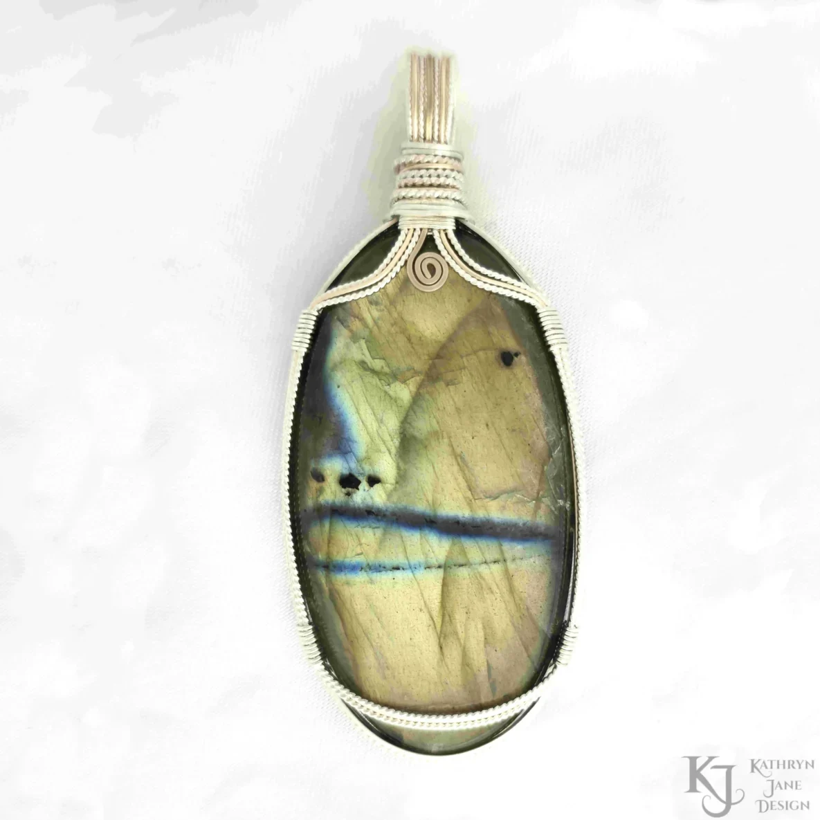 This elongated oval-shaped labradorite pendant has a secure, open support of twisted sterling silver strands either side of 9 carat gold, with a top spiral of square 9 carat gold wire accentuating the golden tones, and symbolising growth.