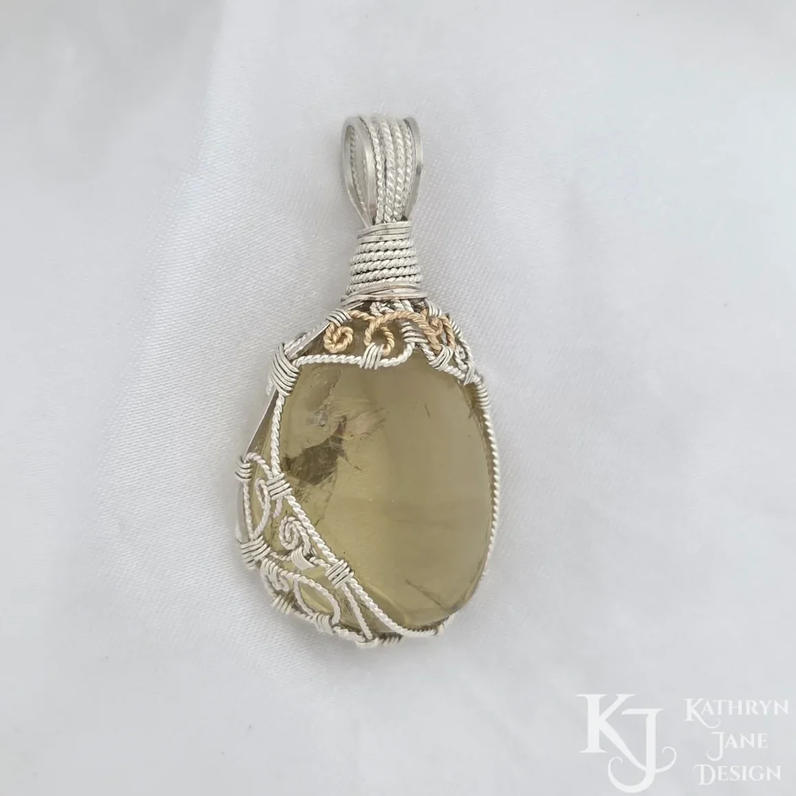 The 14k gold-filled spiral details add a beautiful extra dimension to this gorgeous tumbled lemon quartz pendant, with its ornately spiralled sterling silver framework.