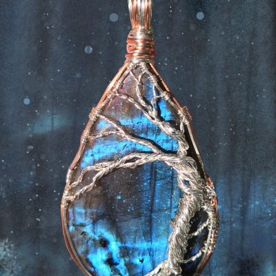 Sterling silver tree on a flashy blue labradorite. The background scene is based upon the image divined within the labradorite - snow falling in a dark, wintry forest at night.