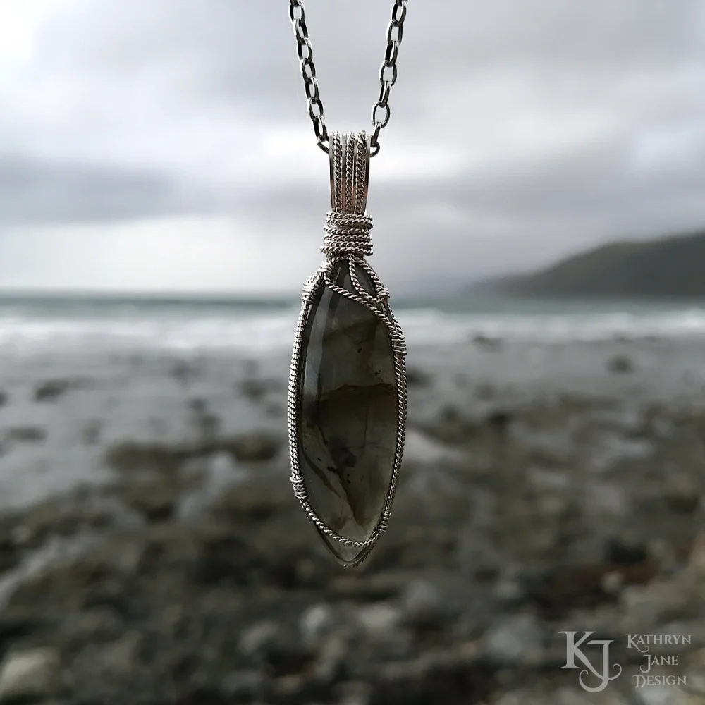 The front of this marquise-shaped labradorite is supported by the flowing design of a single twisted strand of silver.