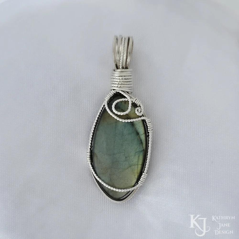 This marquise-shaped labradorite is supported in front by the flowing and spiral design of a single twisted strand of silver.