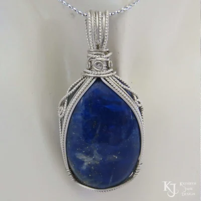 Oval lapis lazuli, with elegant, symmetrical supporting frame and swirls of sterling and Argentium sterling silver.
