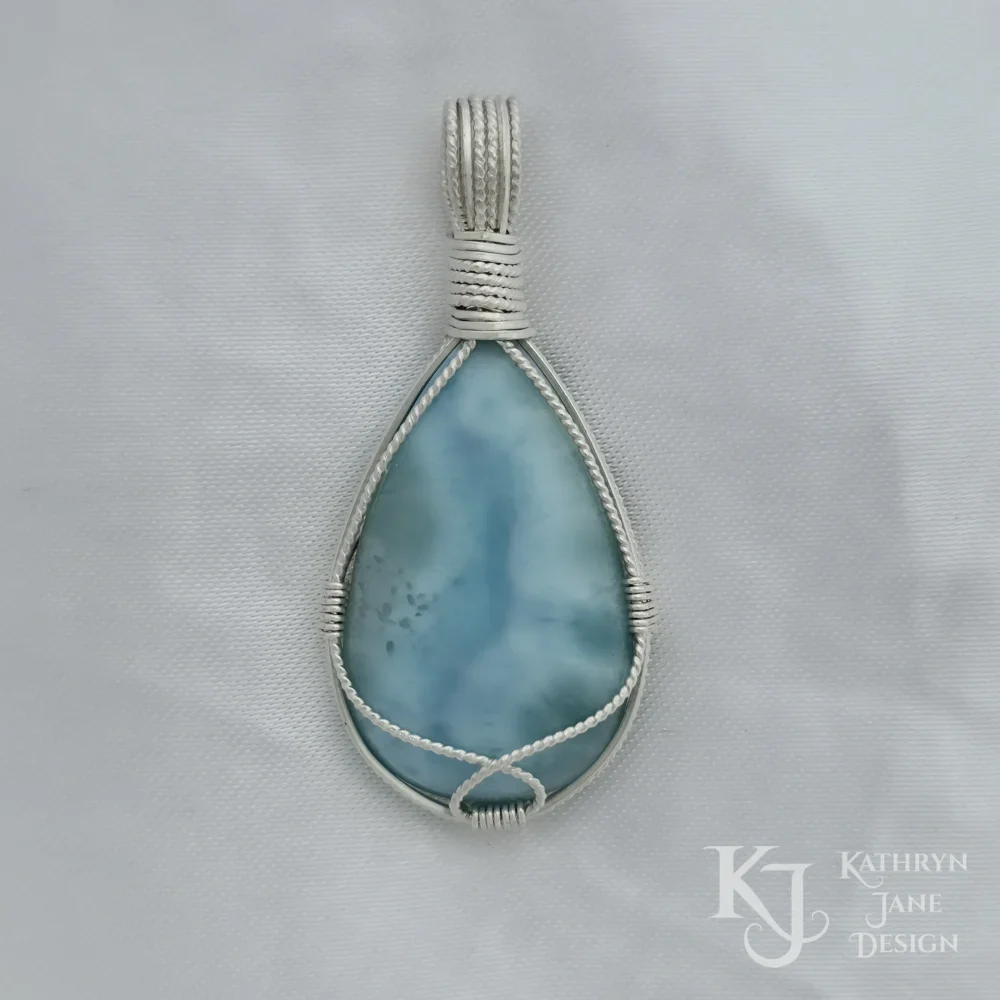 The single twisted silver strand provides a free, open frontal support for this peardrop-shaped larimar.