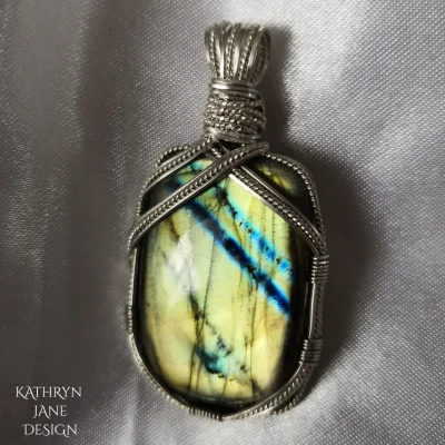 Gold labradorite oblong with silver stripes mirroring the electric blue stripes in the stone.