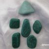 Amazonite Amazonite tumbled gemstone crystals. Turquoise-coloured stones of different shapes. White satin background.