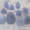 Blue chalcedony Blue chalcedony polished gemstone crystals in various freeform shapes. Lilac blue in colour, and opaque. White satin background.