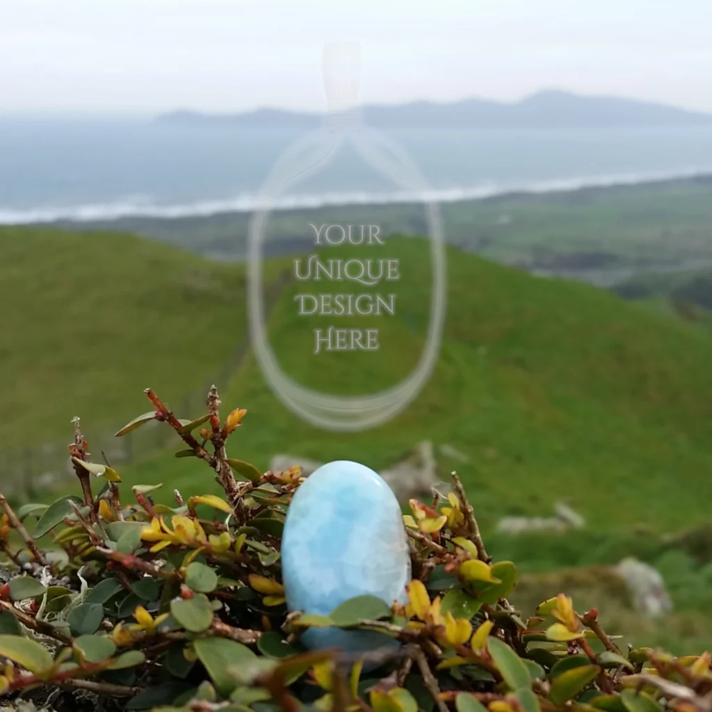 An oval larimar cabochon in the foreground, with Kapiti Island sitting on the horizon in the distance. The words, Your Unique Design Here inside the outline of a pendant's frame. Just for you, a special stone becomes a custom-made crystal pendant