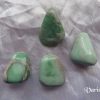 Variscite Variscite gemstone crystals, pale green, opaque, tumbled polished stones of various shapes on white satin background.