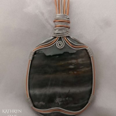 There appears a storm raging over the sea in this polished pietersite stone. 