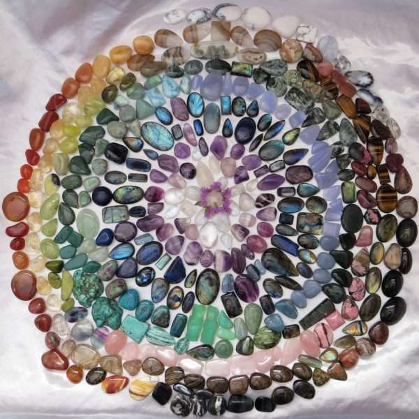 Choose from Kathryn's extensive range of carefully selected gemstone crystals, or have her craft your own sacred taonga (treasure) into a beautiful, unique pendant. A large selection of natural gemstone crystals, arranged in a circle to form a rainbow mandala.