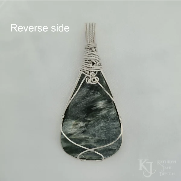 Reverse side of dark green seraphinite, natural stone, teardrop-shaped pendant, wire-wrapped in twisted sterling silver wire in a simple, outer framework, by Kathryn Jane Design. Plain white background.