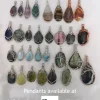 Kathryn Jane Design pendants available at The Capricorn Spirit, Levin and Wellington. background. Kathryn Jane Design pendants available at The Capricorn Spirit, Levin and Wellington. Writing with gemstone crystal pendants behind on a white background.