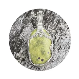 Apple-green oval Atlantisite gemstone crystal pendant on mossy silvered wood background. Sterling silver wire-wrapped pendant with silver spiral top centre. White circle frame overlay.