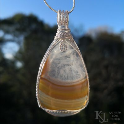 Symmetrical design of square sterling and twist Argentium silver frame this NZ carnelian pendant beautifully.