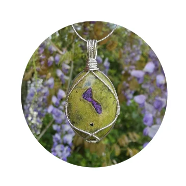 Kathryn Jane Design wire-wrapped Atlantisite pendant with sterling silver forming a framework. Light purple flowers accent the purple stichtite in the middle of the green serpentine