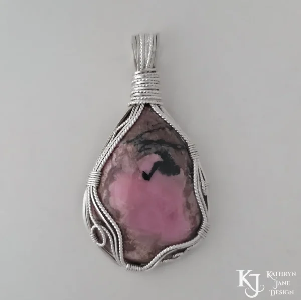 Wire-wrapped Kathryn Jane Design sterling silver rhodonite pendant on white background