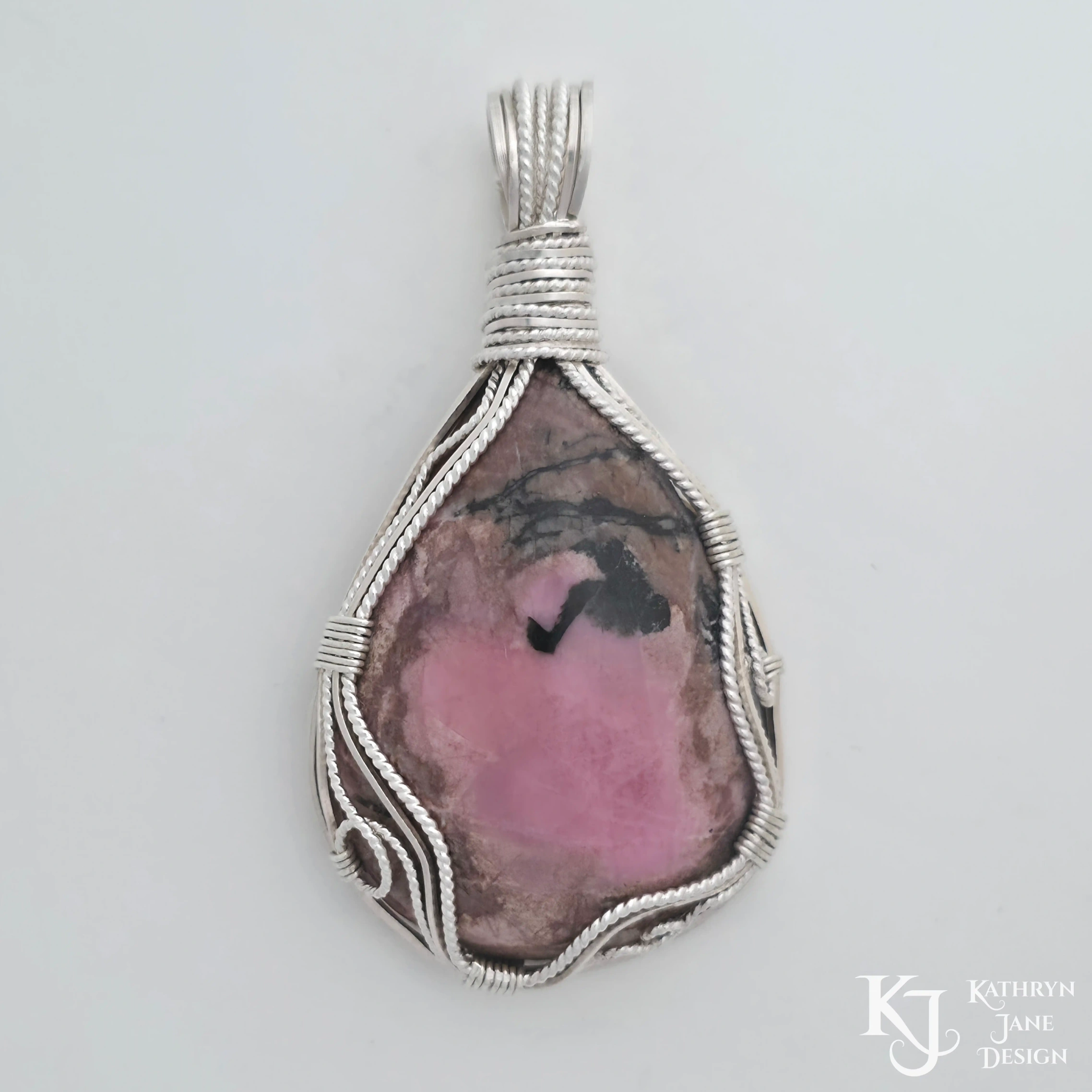 Wire-wrapped sterling silver Kathryn Jane Design rhodonite pendant on white background
