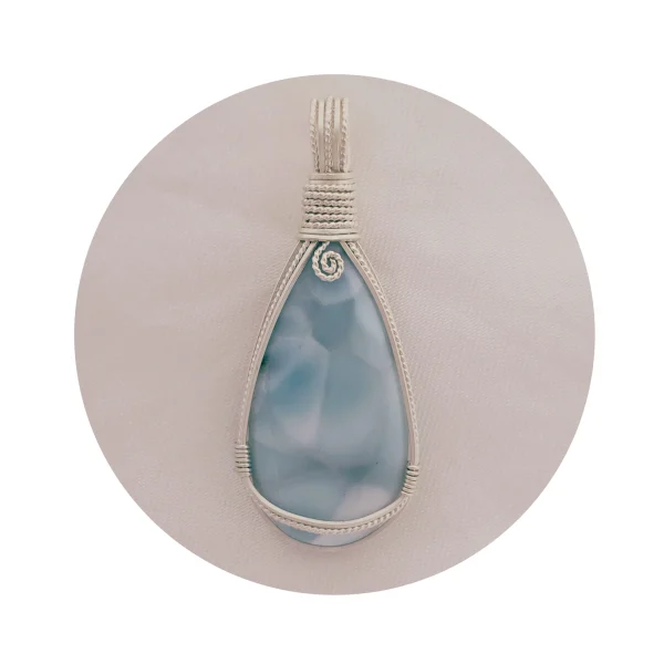 Peardrop-shaped larimar pendant, soft blue-turqoise, framed in sterling silver wire. Kathryn Jane Design wire-wrapped pendant. White circular frame