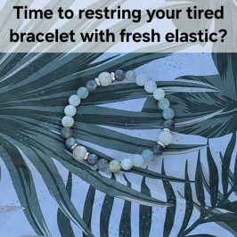 Time to restring your tired bracelet with fresh elastic. A bracelet of various shades of green gemstone beads on top of a mat with a leaf design