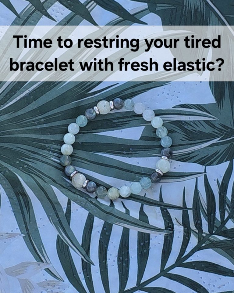 Time to restring your tired bracelet with fresh elastic. A bracelet of various shades of green gemstone beads on top of a mat with a leaf design