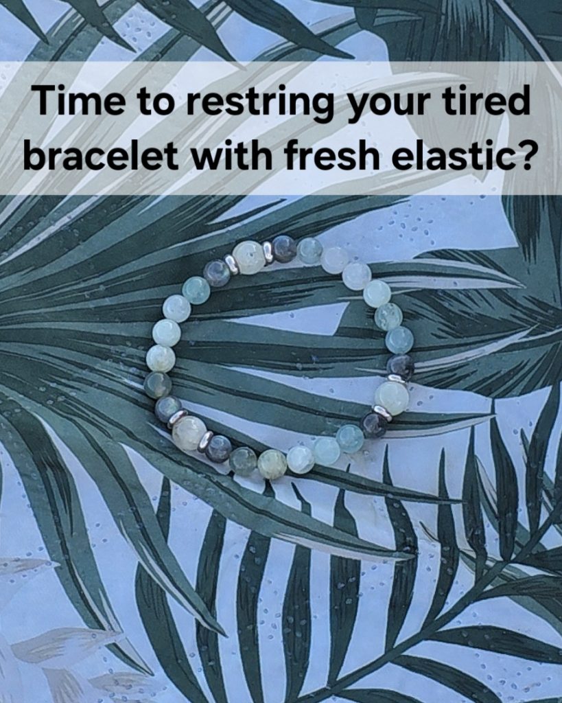 Time to restring your tired bracelet with fresh elastic. A bracelet of various shades of green gemstone beads on top of a mat with a leaf design