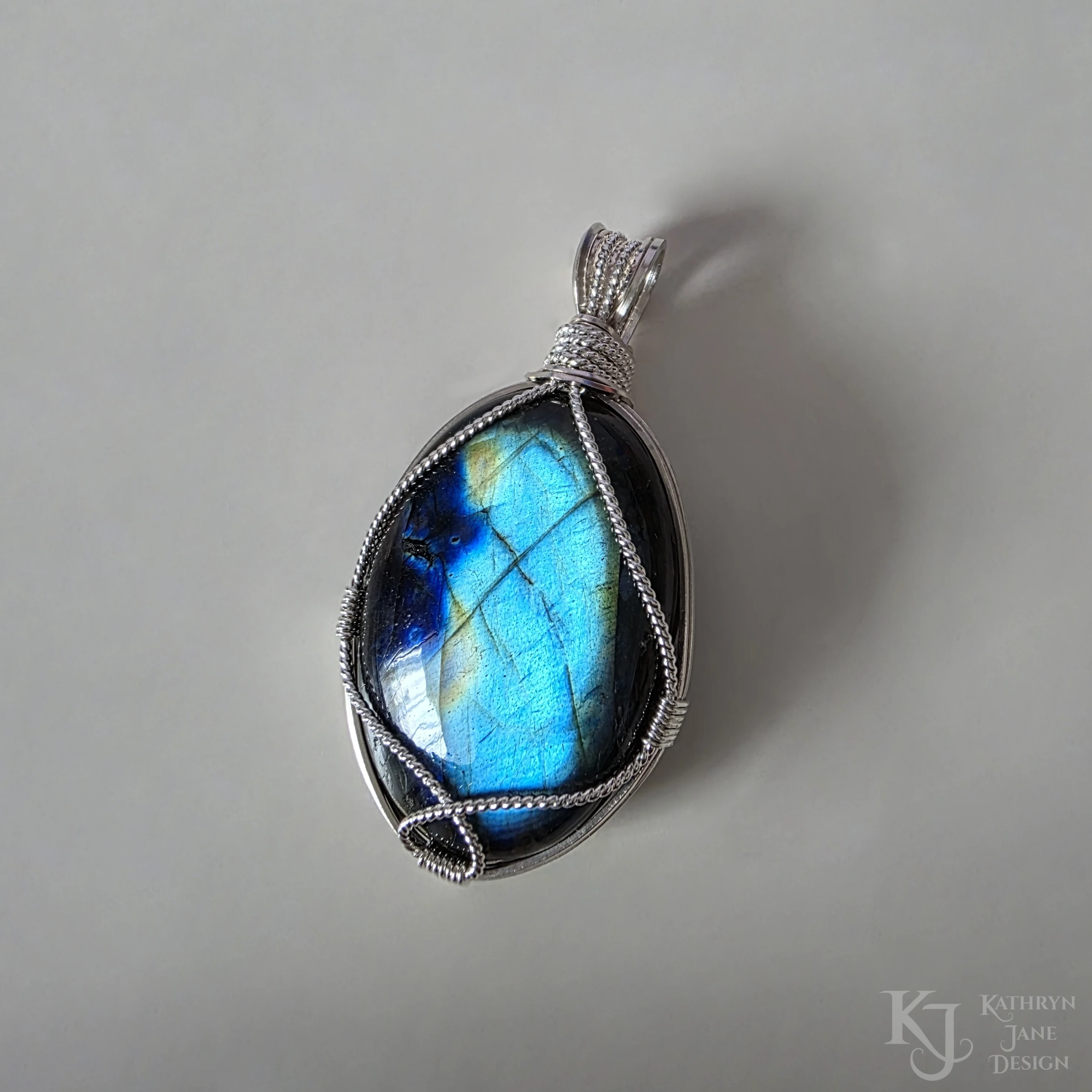 Kathryn Jane Design wire-wrapped labradorite pendant with sterling silver forming a framework. White background.
