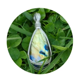 Kathryn Jane Design wire-wrapped labradorite pendant with sterling silver forming a framework. Grass background.