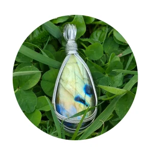 Kathryn Jane Design wire-wrapped labradorite pendant with sterling silver forming a framework. Grass background.