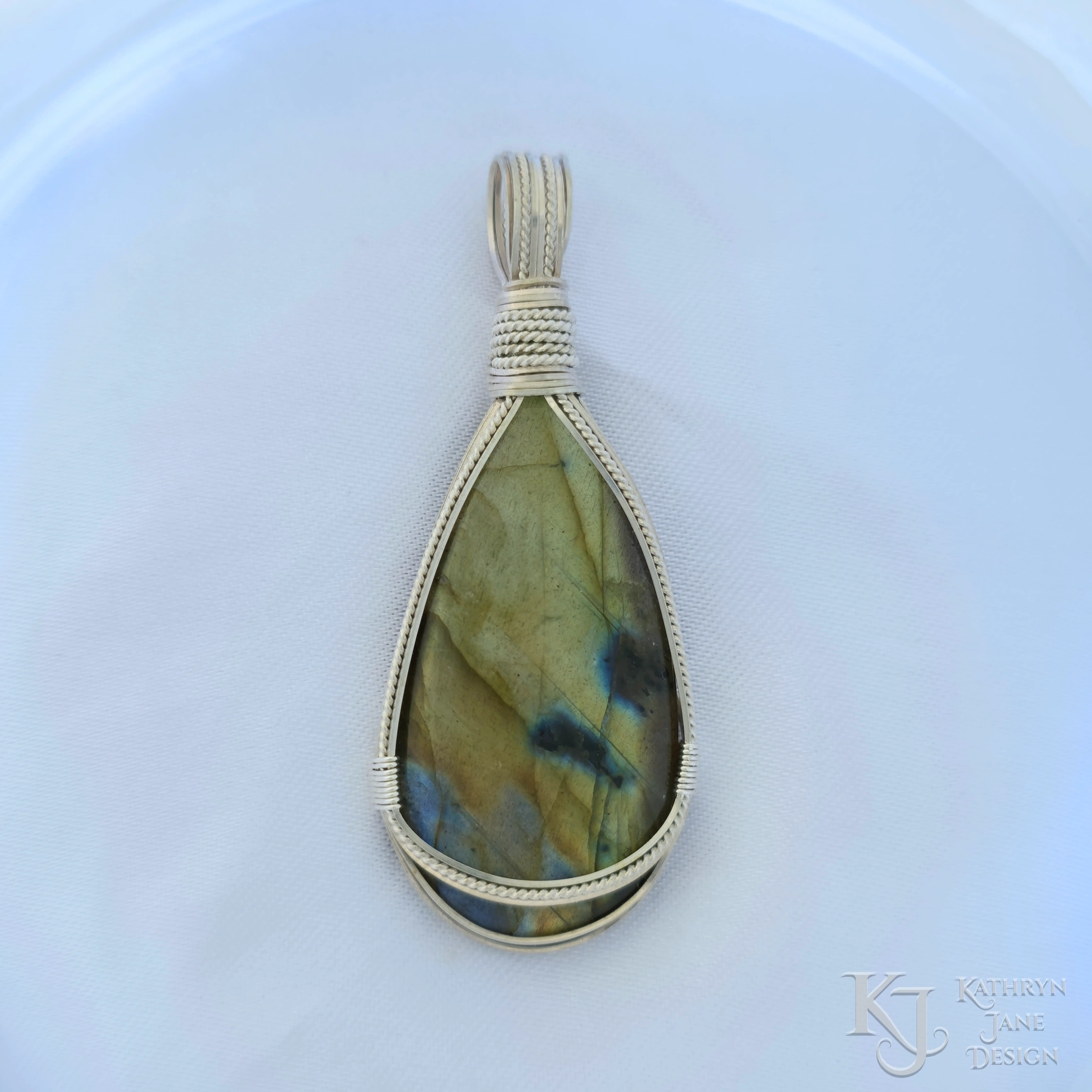 Kathryn Jane Design wire-wrapped labradorite pendant with sterling silver forming a framework. White background.