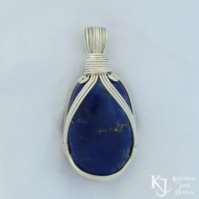 "Halter-neck" silver design on this oval lapis lazuli, with spiral epaulettes on the shoulders