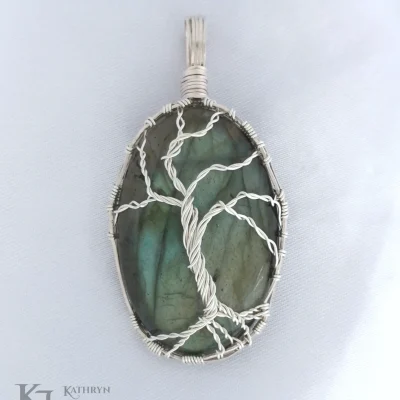 Flashy green labradorite oval provides a wonderful background for the sterling silver tree