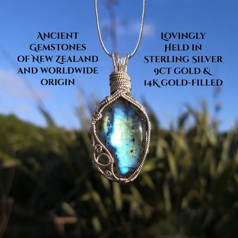 labradorite pendant surrounded by silver, blue sky top background and flaxes down below. Ancient gemstones of New Zealand and worldwide origin lovingly held in sterling silver, 9ct gold and 14k gold-filled