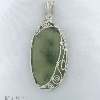 Spirals and swirls providing an elegant frame on this elongated oval prehnite