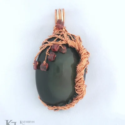 Oval rainbow obsidian hugged by copper tree with garnet 'fruit'