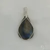 Photo taken in a filter cone to eliminate appearance of reflections off the surface Triangular-shaped natural labradorite pendant in a simple sterling silver framework on white satin background.
