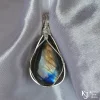 Inside, natural light Triangular-shaped natural labradorite pendant in a simple sterling silver framework on white satin background. Light reflecting off reveals gold and blue labradorescence