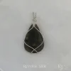 Reverse side taken in filtered light Reverse side of triangular-shaped natural labradorite pendant in a simple sterling silver framework on white satin background.