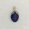 Photo taken in filter cone, eliminating the appearance of reflections off the highly polished surface of the stone Oblong-shaped royal blue lapis lazuli pendant with sterling silver and 14k gold-filled wire spirals at the top, and in the bail. White satin background with Kathryn Jane Design logo in the bottom right