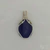 Photo taken in filter cone, eliminating the appearance of reflections off the highly polished surface of the stone Oblong-shaped royal blue lapis lazuli pendant with sterling silver and 14k gold-filled wire spirals at the top, and in the bail. White satin background with Kathryn Jane Design logo in the bottom right