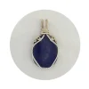 Oblong-shaped royal blue lapis lazuli pendant with sterling silver and 14k gold-filled wire spirals at the top, and in the bail. White background