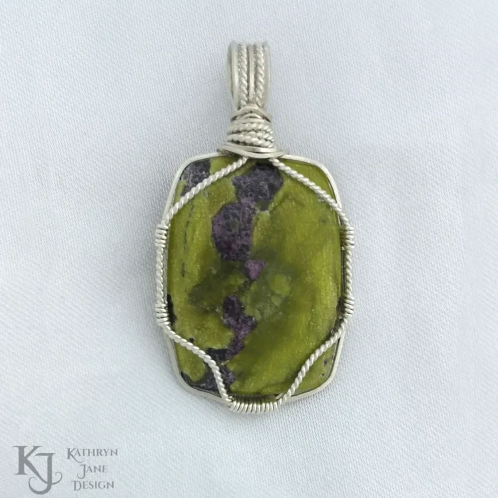 A single twisted sterling silver strand provides a simple support for this oblong-shaped Atlantisite (stichtite in serpentine). The frame almost 'disappears' with the eye drawn instead to the unencumbered face of the stone.