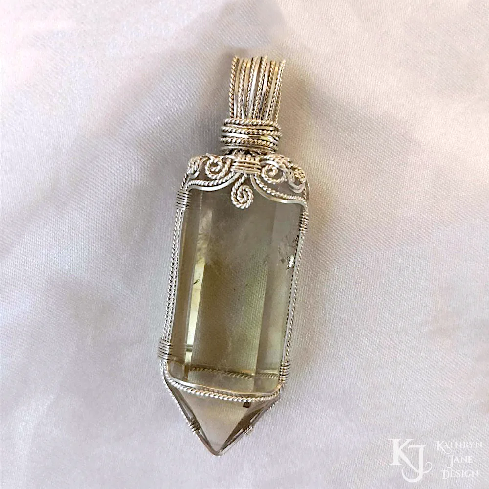 Crowned by spirals, alternating square and twisted silver wires support this citrine point.